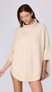 Gebreide poncho in een ecru tint met een comfortabele colkraag en korte mouwen. Het losse silhouet en de zachte knitwear kwaliteit maken dit een warm en veelzijdig item voor frisse dagen. Verkrijgbaar in de maten XS/S tot XL/XXL.